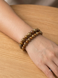 Set de deux bracelets perles dorées sculptées portés sur un poignet